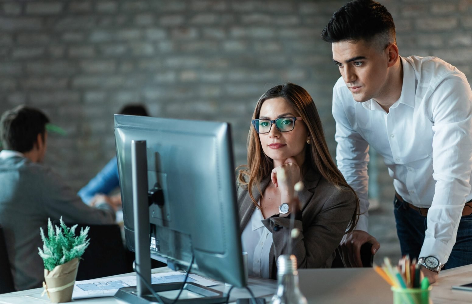 Two young entrepreneurs working on a computer and reading an e-mail in the office.